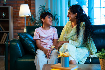 Indian Mother and son sharing warm chat on sofa, showing love and bonding in modern home