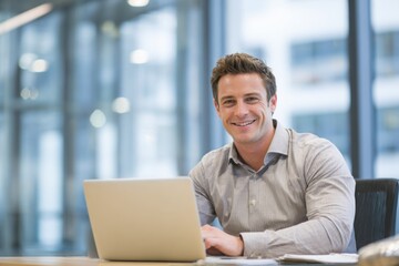 Fototapeta premium smiling young man working on a laptop in the office handsome, mature male businessman smiling while using his computer at his work desk.