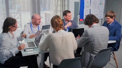 Professional business team engaged in strategic planning discussion during an office meeting. Marketing officer and colleagues seated around table, analyzing data and developing corporate growth plan. - Powered by Adobe