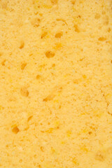 A full-frame, close-up shot captures the porous, golden-yellow texture of a freshly baked lemon sponge cake