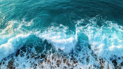 Aerial View of Blue Ocean Waves Crashing on Rocky Shoreline