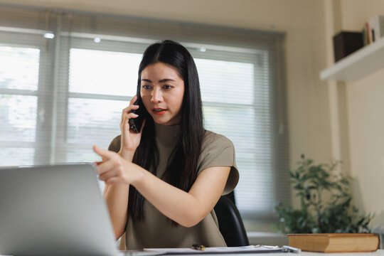 Asian woman discussing work issues pointing at laptop - Powered by Adobe