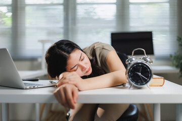 Woman sleeping on desk feeling exhausted from overwork