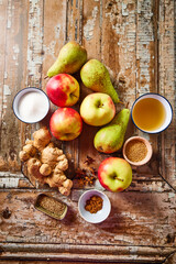Flat lay with ingredients for making apple and pear chutney on a rustic background with ginger, vinegar, sugar and mustard seeds