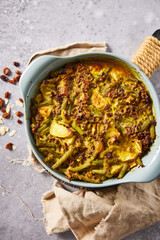 Traditional South African bobotie served with yellow rice, chutney, raisins, and almonds. Overhead view of a spiced ground meat and vegetable casserole, a classic Cape Malay dish.