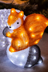 Glowing decorative squirrel with festive lights for Christmas home and winter garden decoration, selective focus