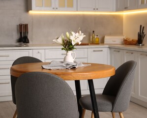 Dining table, chairs and floral decor in kitchen. Interior design