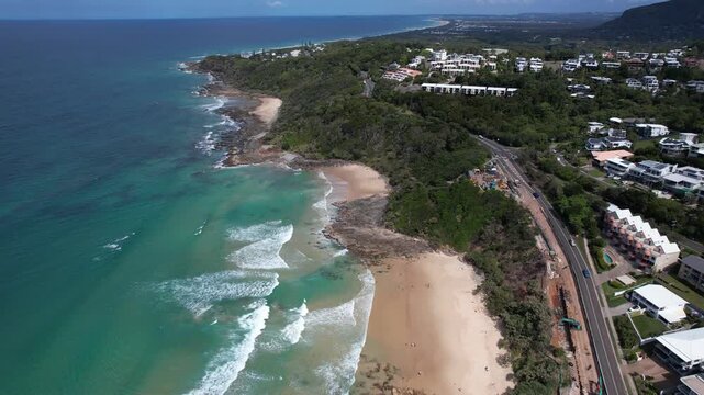 Waves In The Sandy Shore Of Coolum Beach In Summer With Coastal Road And Buildings In QLD, Australia. - aerial shot