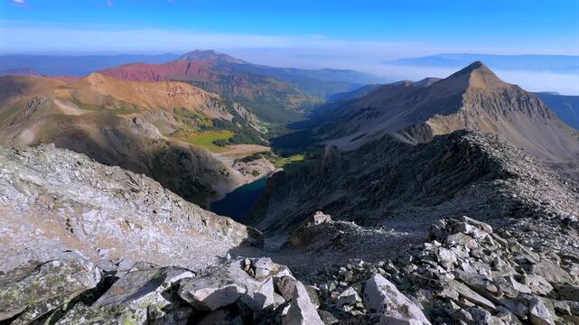 Capitol Lake Aspen Snowmass Rocky Mountain nature landscape valley view Capitol Peak Wilderness North East Ridge Route Mount Daly K2 Clark Peak aerial drone Colorado sunny blue sky morning clouds pan