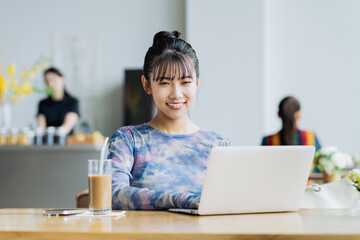 カフェで仕事をするフリーランスの若い女性