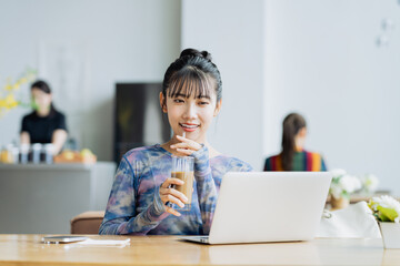 カフェで仕事をするフリーランスの若い女性