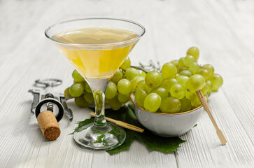 White Wine or Cocktail with Green Grapes on a Rustic Wooden Table