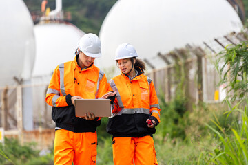 Chemical Engineers Reviewing Operations at Refinery Tank Farm, Industrial Site Team Discussing Project near Large Storage Tanks, Oil and Gas Workers with Laptop Planning Field Logistics