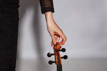 Violinist tuning instrument with a graceful hand at a studio during a music session