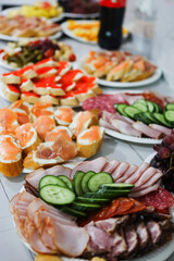 Colorful spread of appetizers and snacks served on white plates at a gathering