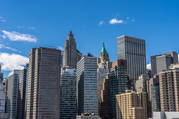 Fototapeta premium Lower Manhattan highrise buildings skyline view from Brooklyn bridge in a sunny day.