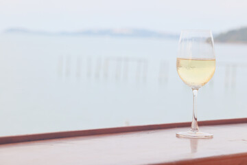 glass of cold white wine on the summer seashore by the water, relaxing by the water, a gentle background of soft color