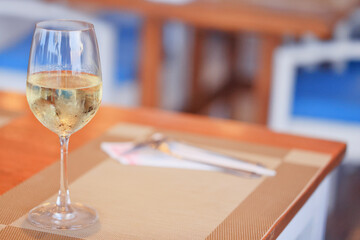 a glass of cold white wine and serving in the restaurant