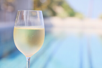 glass of cold white wine on the summer seashore by the water, relaxing by the water, a gentle background of soft color
