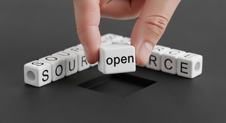 Open source concept with letter cubes and hand on dark surface.