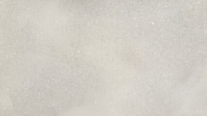 Foam background texture in water. Relaxing atmosphere of bath bubbles. Abstract white soapy foam surface in close-up
