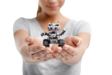 A person gently holds a small, intricate gray robot with red eyes and tank treads in cupped hands, symbolizing human connection with AI. background removed