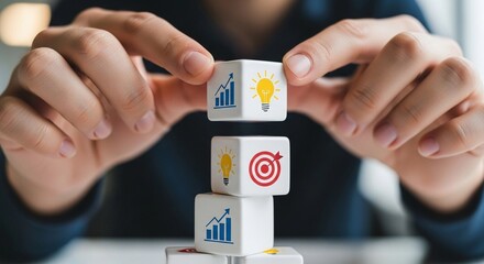Hands stacking white cubes with business icons representing strategy, innovation, and goal setting for growth and development.