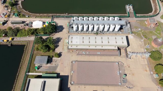 Aerial view of the Edgbaston Reservoir and adjacent water treatment plant, contrasting the cool water with the warm brick buildings, Birmingham, England, United Kingdom.