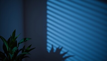 Shadow of plant with blue stripes on wall from window blinds  