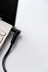 Charging laptop with power adapter isolated on white background