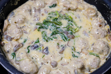 Homemade food, meatballs with spinach in a creamy sauce