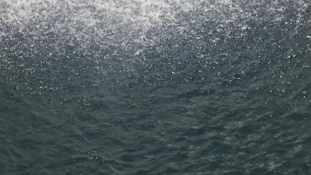 Beautiful waterfall drops splashing on water surface in slow motion calm nature background, perfect abstract video for relaxation, spa, travel, advertising and documentary projects. 120 fps video.