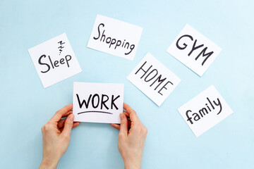Hand is choosing Work card from many paper cards with hand drawing of different life activities. Life balance concept.