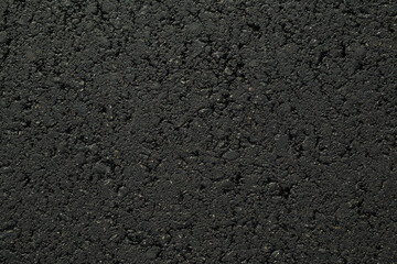 New dark black asphalt background. Closeup. Empty place for text. Top down view.
