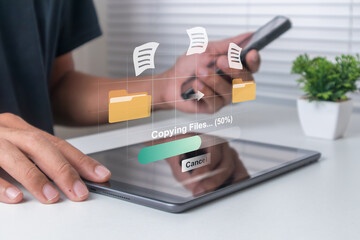 Transfer data or copy files between devices. Man transfer files from mobile phone to tablet computer.