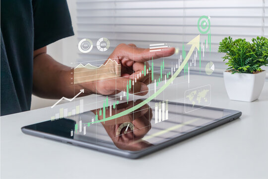 Businessman analyzing business investment and market growth with digital chart on tablet computer to achieve target