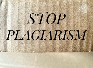 Message Stop Plagiarism written on brown cardboard surface.