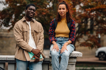 Two happy university students relaxing outdoors on campus