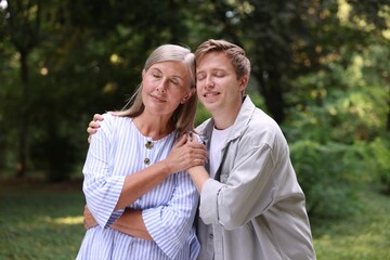Fototapeta premium Mother and her happy son outdoors. Family bonding