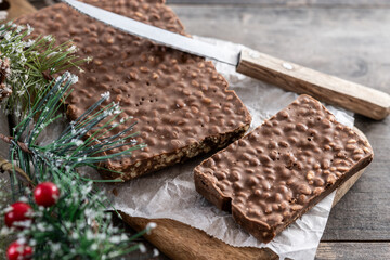 Traditional pieces of delicious Christmas chocolate nougat on wooden table. Copy space