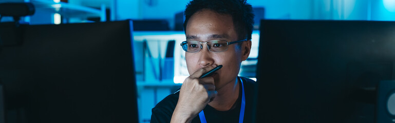 Software engineer analyzing programming language code, focusing on cybersecurity, IT systems, and digital data security in dark office.