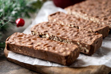 Chocolate nougat bar with puffed rice on wooden table