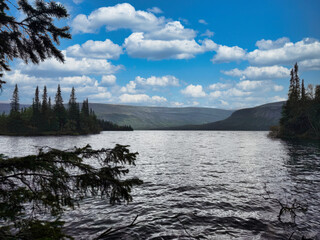 A lake with a cloudy sky in the background