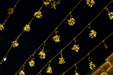 Festive display of glowing yellow lights hanging in decorative clusters, warm and joyful atmosphere...