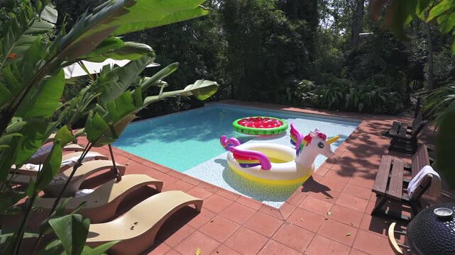 Pool at jungle lodge in Misiones, Argentina features unicorn and strawberry floats, terracotta tiles, and lush greenery&mdash;capturing playful leisure in the heart of the Selva Misionera