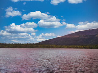 A beautiful blue sky with a few clouds and a mountain in the background