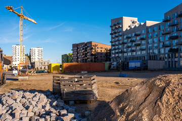 Active construction site in Copenhagen with crane, materials and modern buildings in progress symbolizing development and branding opportunities