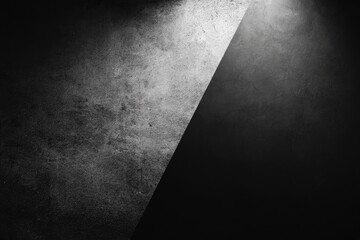 Grayscale image with textured surface divided diagonally, showcasing contrast between light and shadow
