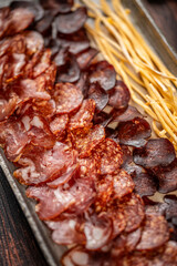 Assorted salami and cured meat slices with breadsticks