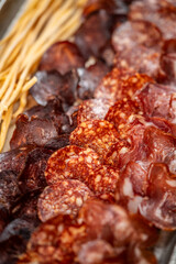 Assorted cured meats and salami slices with breadsticks